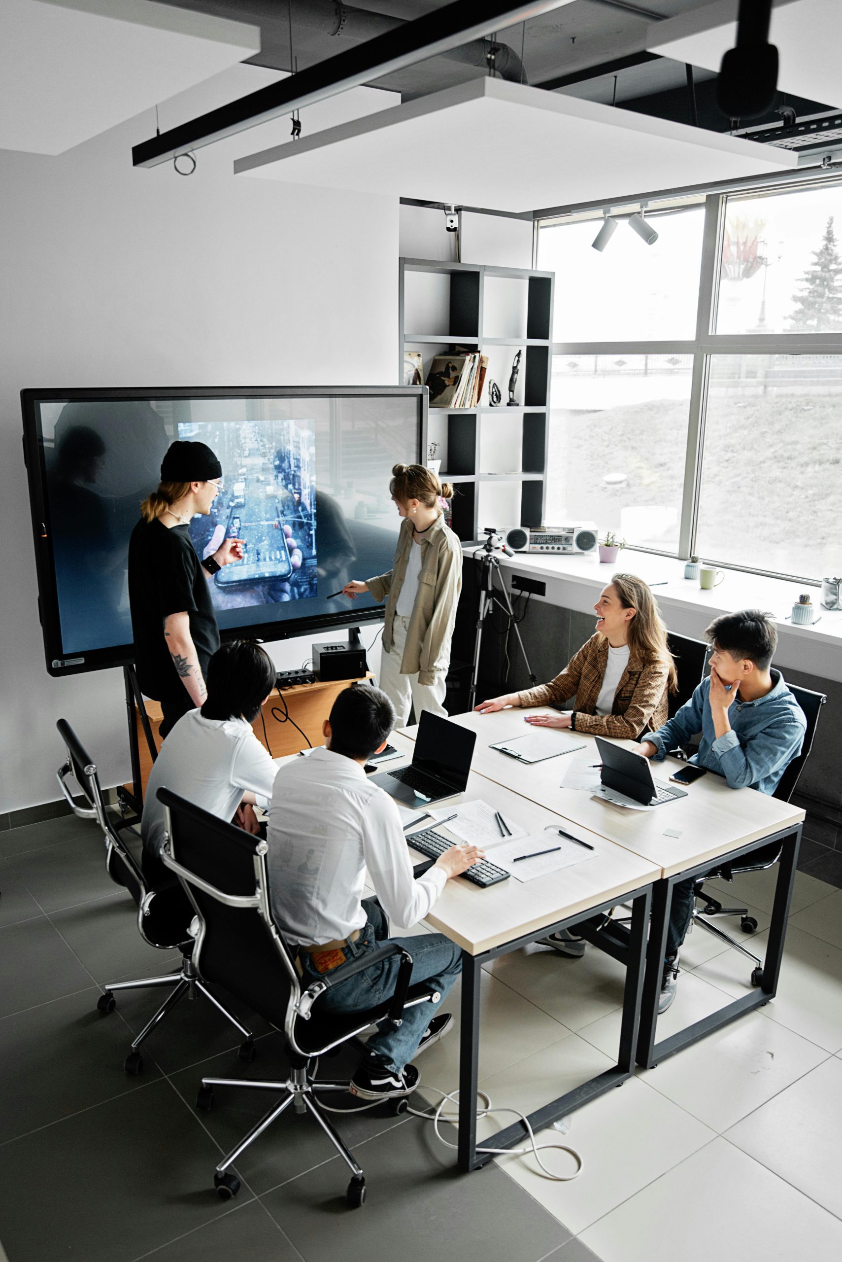 Modern office meeting with diverse team using technology for collaboration.