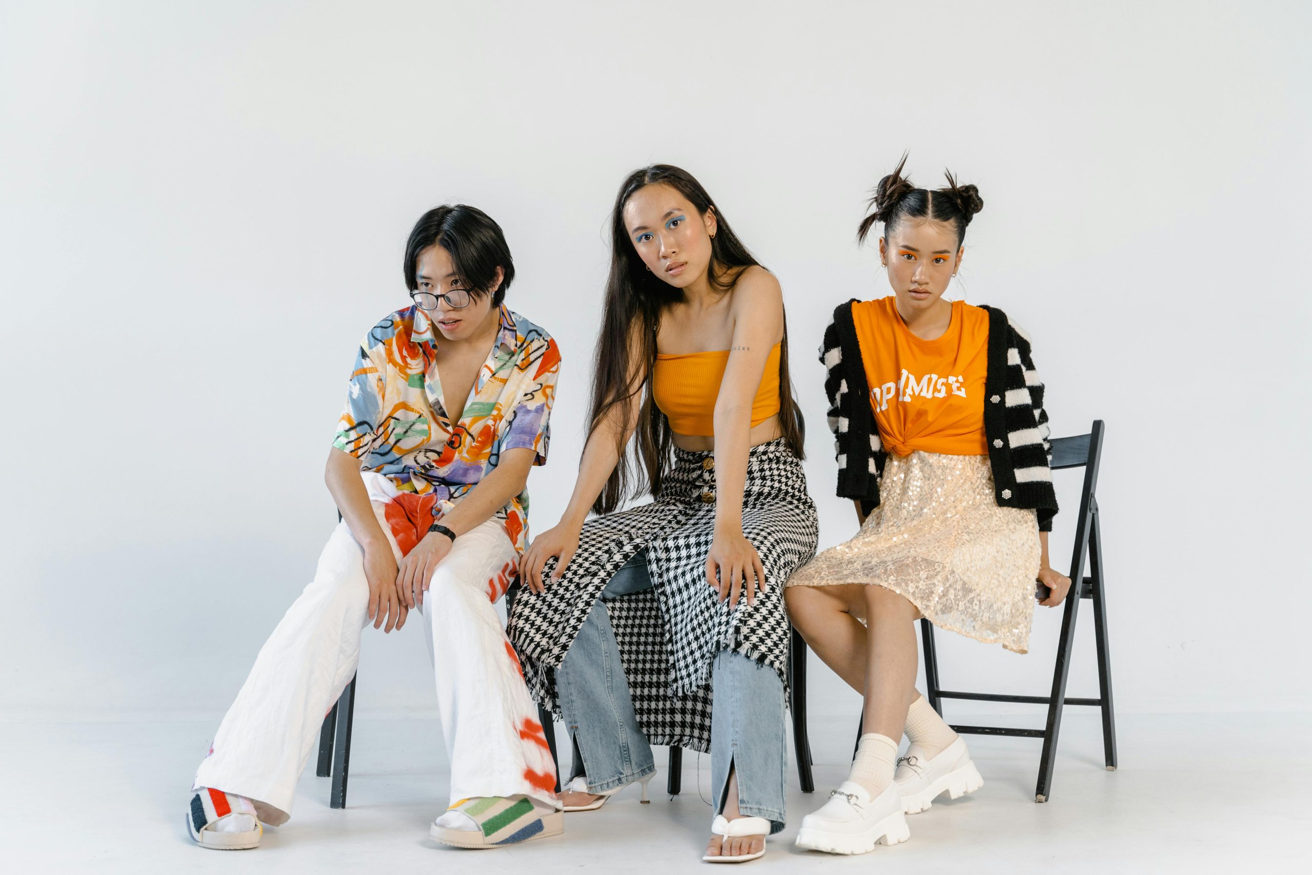 Three teenagers showcasing diverse and expressive fashion in a studio setting.